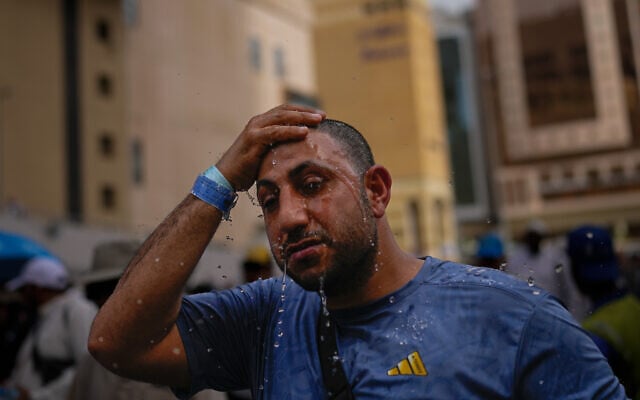 A Muslim pilgrim splashes water over his head too cool down outside the Grand Mosque during the annual hajj pilgrimage at the holy city of Mecca, Saudi Arabia, May 24, 2026. (AP Photo/Altaf Qadri)