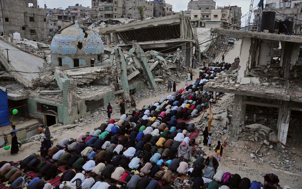 Palestinians offer Eid al-Adha prayers beside the ruins of a mosque destroyed by Israeli bombardment, in Khan Younis, southern Gaza Strip, May 27, 2026. (AP Photo/Abdel Kareem Hana)