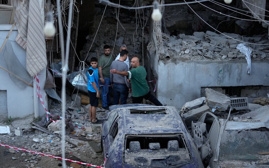 People gather outside a destroyed apartment that was hit in an Israeli airstrike in the southern port city of Sidon, Lebanon, Thursday, May 28, 2026. (AP Photo/Mohammed Zaatari)
