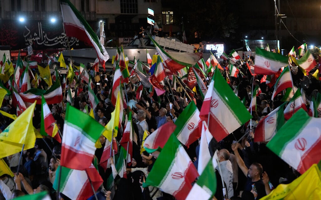An assault speed boat is displayed by Iran's Revolutionary Guard as demonstrators wave Iranian flags and flags for Lebanon's Hezbollah terror group during a pro-government gathering at Islamic Revolution Square in Tehran, Iran, May 30, 2026. (AP Photo/Vahid Salemi)