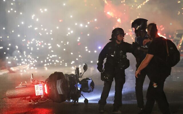 Police try to disperses PSG supporters who left off fireworks as they celebrate in Paris, Saturday, May 30, 2026 after the Champions League final soccer match between Paris Saint-Germain and Arsenal that was played in Budapest, PSG won the game. (AP Photo/Thomas Padilla)