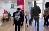 A police officer confiscating a Palestinian flag from the Hadash youth center in Umm al-Fahm on May 1, 2026. (X, used in accordance with Clause 27a of the Copyright Law)