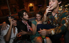 Illustrative: Israelis smoke cigarettes and drink beer at a party in the center of Jerusalem, August 20, 2009. (Miriam Alster/Flash90)