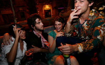 Illustrative: Israelis smoke cigarettes and drink beer at a party in the center of Jerusalem, August 20, 2009. (Miriam Alster/Flash90)
