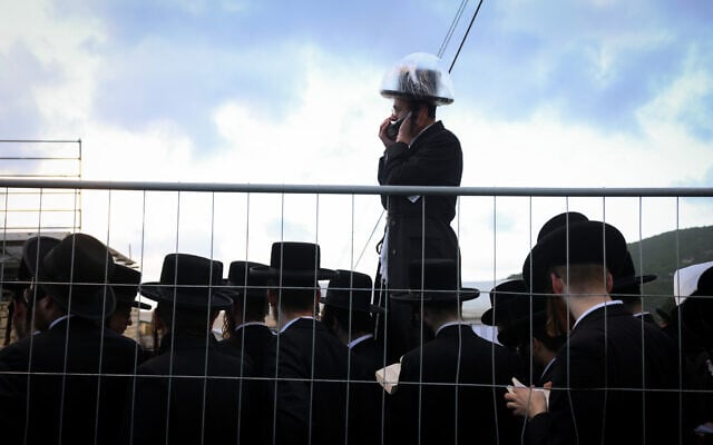 Ultra-Orthodox Jews gather behind a fence for Lag B'Omer celebrations at Mount Meron in northern Israel on May 4, 2026. (David Cohen/Flash90)