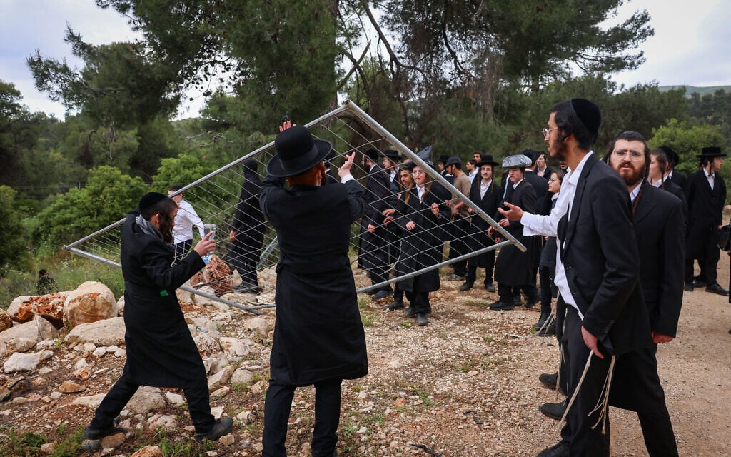 Ultra-Orthodox Jews walk through a forest, breaking down barriers to enter Meron on Lag B'Omer, after the site was closed by police following Home Front Command restrictions, May 5, 2026. (David Cohen/Flash90)