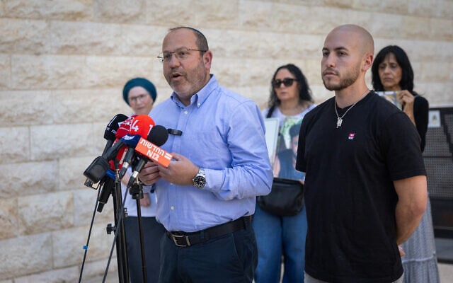 Former hostage Eitan Mor (R) and his father Tzvika speak outside a hearing on October 7, outside the Supreme Court in Jerusalem, May 10, 2026 (Yonatan Sindel/Flash90)