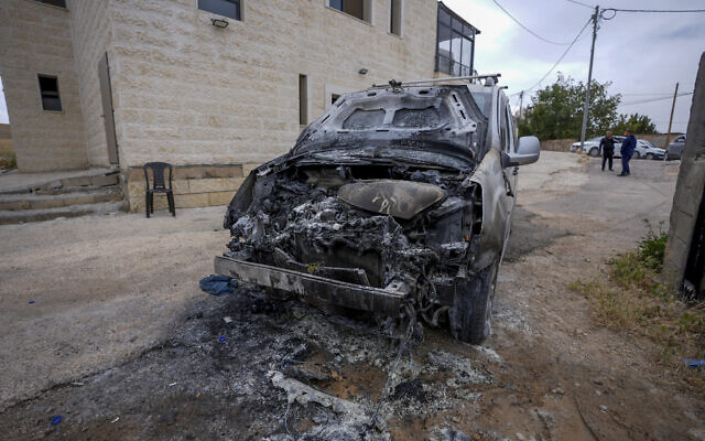 A man stands near a burned car and graffiti on a mosque wall, which Palestinians say was made by extremist Israeli settlers, in the village of Jibya, north of Ramallah in the West Bank, May 15, 2026. (Flash90) A man stands near a burned car and graffiti on a mosque wall, which Palestinians say was made by extremist Israeli settlers, in the village of Jibya, north of Ramallah in the West Bank, May 15, 2026. (Flash90)