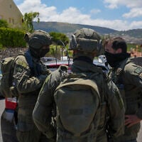 Israeli security forces are seen outside a home in Metula, near the Israel-Lebanon border, that was hit by a Hezbollah unmanned aerial vehicle on May 25, 2026. (Ayal Margolin/Flash90)