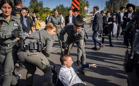 Ultra-Orthodox Jewish men block a road in Bnei Brak during a protest against the jailing of yeshiva students who failed to comply with an army recruitment order, May 28, 2026. (Flash90)