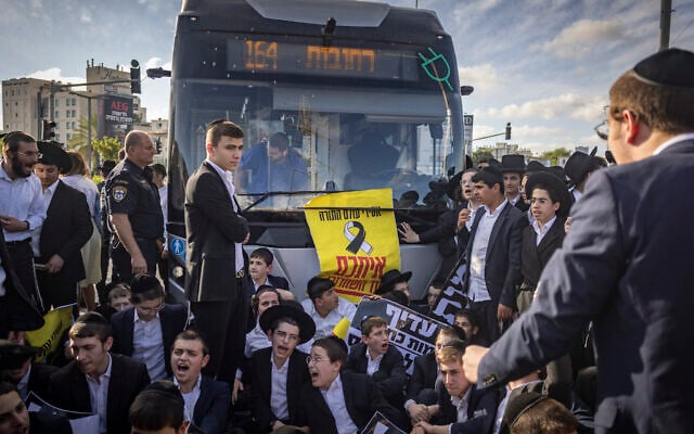 Ultra-Orthodox men block a road in Bnei Brak during a protest against the jailing of yeshiva students who failed to comply with the military draft, May 28, 2026. (Flash90)