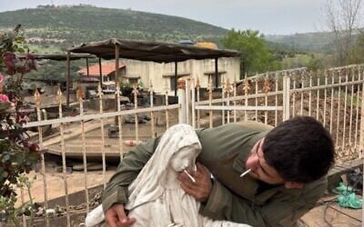A soldier places a cigarette into the mouth of a Virgin Mary statue in Debel, southern Lebanon, in a photo circulated online on May 6, 2026. (Used in accordance with Clause 27a of the Copyright Law)