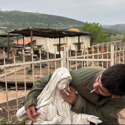 A soldier places a cigarette into the mouth of a Virgin Mary statue in Debel, southern Lebanon, in a photo circulated online on May 6, 2026. (Used in accordance with Clause 27a of the Copyright Law)