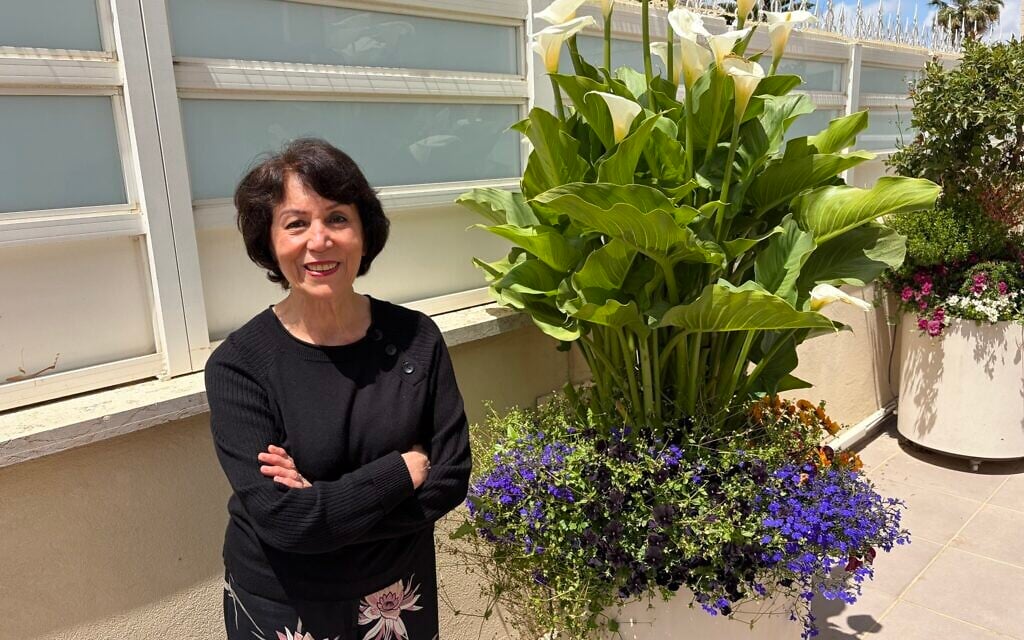 Artist Farideh Golbahar with the flowers she tends at her Jerusalem home, May 2026 (Jessica Steinberg/Times of Israel)