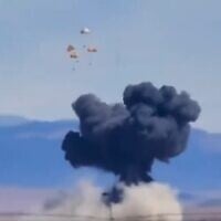 Four pilots parachute toward the ground as a plume of smoke rises above a plain near Mountain Home Air Force Base, Idaho, where two US Navy jets collided at an air show on May 17, 2026. (Screenshot: X/Shane Ogden)