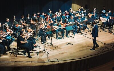Tom Cohen conducts the youth program of The Jerusalem Orchestra East & West in Tel Aviv, May 2026. (Yaakov Buta via JTA) Tom Cohen conducts the youth program of The Jerusalem Orchestra East & West in Tel Aviv, May 2026. (Yaakov Buta via JTA)