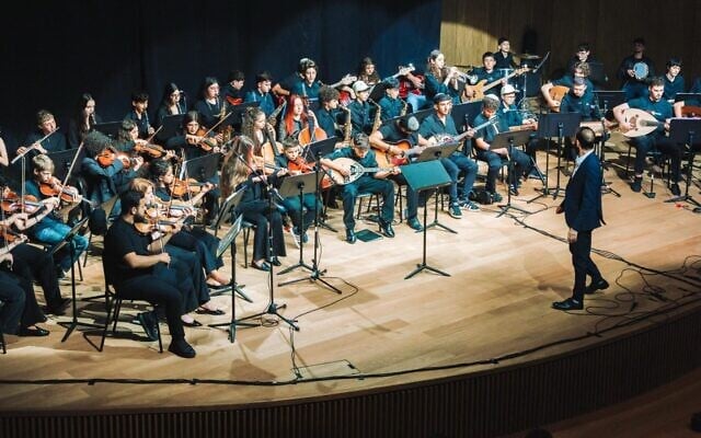 Tom Cohen conducts the youth program of The Jerusalem Orchestra East & West in Tel Aviv, May 2026. (Yaakov Buta via JTA)
