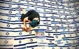Artist Tal Tenne Czaczkes working on her Flag of Flags, a massive canopy made of abandoned Israeli flags now being shown around the country, in May 2026 (Roni Czaczkes)
