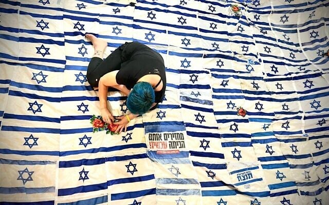 Artist Tal Tenne Czaczkes working on her Flag of Flags, a massive canopy made of abandoned Israeli flags now being shown around the country, in May 2026 (Roni Czaczkes)