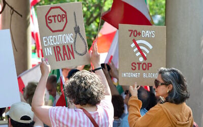 Demonstrators holding signs as they gather near the Francis Scott Key Bridge during rally in support of the Iranian people and to condemn the execution of political prisoners in Iran, in Washington, DC, on May 16, 2026. (Amid Farahi/AFP)