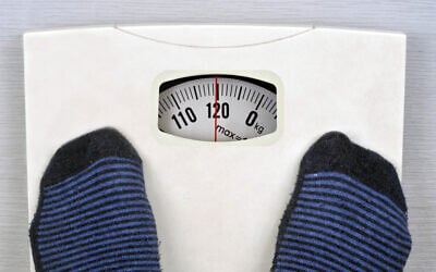 Illustrative photo of a person standing on a scale.  (Richard Villalon/iStock)
