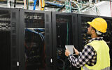 Illustrative: A technician working with a tablet inside a big data center room. (iStock/Getty)