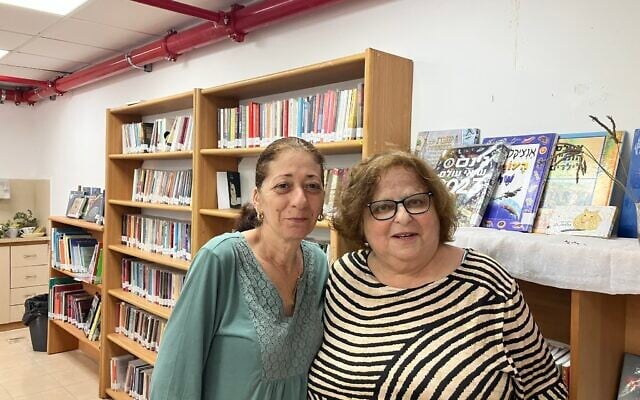 Ayala Ben-David, left, and Galia Handelman, librarians who work now in the temporary library in Shlomi since the regular library was destroyed by a Hezbollah rocket in October 2024, on May 27, 2026. (Diana Bletter/Times of Israel)