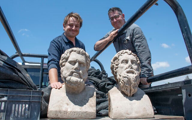 Archaeologists Eliran Oren and Michael Sorotskin with the statues discovered in Binyamina. (Yoli Schwartz/Israel Antiquities Authority)