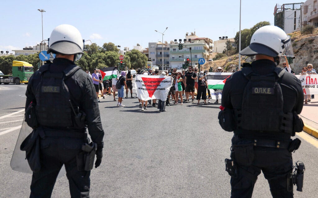 Police officers stand guard as pro-Palestinian demonstrators stage a demonstration against the arrival of Israeli cruise passengers in Heraklion Port, on the island of Crete, on August 28, 2025. (Photo by Costas METAXAKIS / AFP)