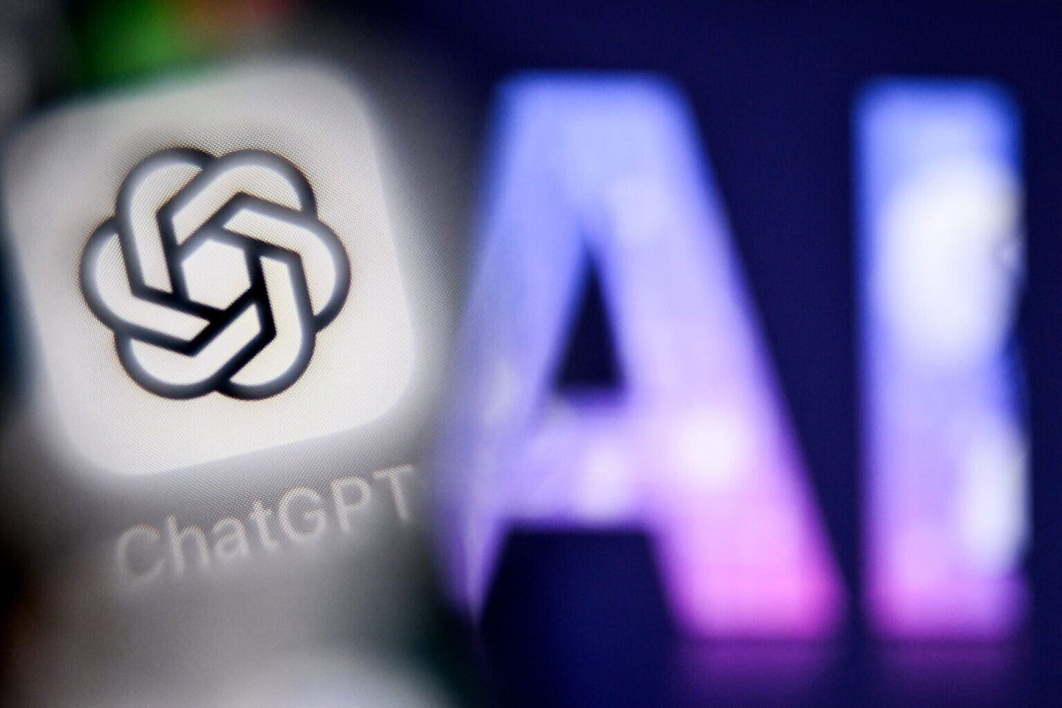 The letters AI, for artificial intelligence on a laptop screen, at right, next to the logo of the ChatGPT application on a smartphone screen, in Frankfurt am Main, Germany, September 1, 2025. (Kirill Kudryavtsev/AFP)