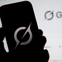 In this photo illustration, the Grok logo is seen on a mobile phone next to the website displayed on a computer screen in Bogota on February 12, 2026. (Pablo Vera/AFP)