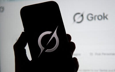 In this photo illustration, the Grok logo is seen on a mobile phone next to the website displayed on a computer screen in Bogota on February 12, 2026. (Pablo Vera/AFP) In this photo illustration, the Grok logo is seen on a mobile phone next to the website displayed on a computer screen in Bogota on February 12, 2026. (Pablo Vera/AFP)