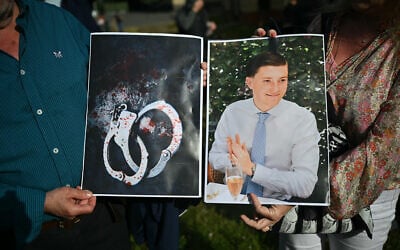 People hold images of victim Henry Nowak, and blood-covered handcuffs as they take part in a protest outside of Southampton Central Police Station in Southampton, southern England, on June 2, 2026, following his murder by Vickrum Digwa. (Justin Tallis/AFP)