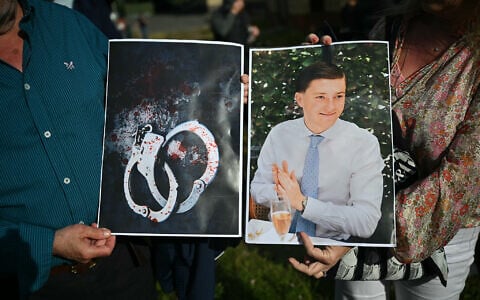 People hold images of victim Henry Nowak, and blood-covered handcuffs as they take part in a protest outside of Southampton Central Police Station in Southampton, southern England, on June 2, 2026, following his murder by Vickrum Digwa. (Justin Tallis/AFP)