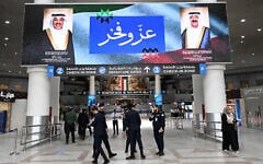 Kuwaiti security officers stand beneath a screen displaying portraits of the Emir of Kuwait Sheikh Meshal al-Ahmad al-Jaber al-Sabah (R) and the Kuwaiti crown prince Sheikh Sabah al-Khaled al-Hamad al-Sabah, alongside the words "Pride and Glory," at Kuwait International Airport in Kuwait City on June 1, 2026. (YASSER AL-ZAYYAT / AFP)