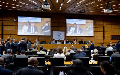 The Chairperson of the IAEA's Board of Governors for 2025-2026 David Grainge Biggs, who is also Australia's Resident Representative to the IAEA, seen on two screens (C) as he opens the International Atomic Energy Agency (IAEA) Board of Governors' Meeting at the agency's headquarters in Vienna, Austria on June 8, 2026. (Joe Klamar / AFP)