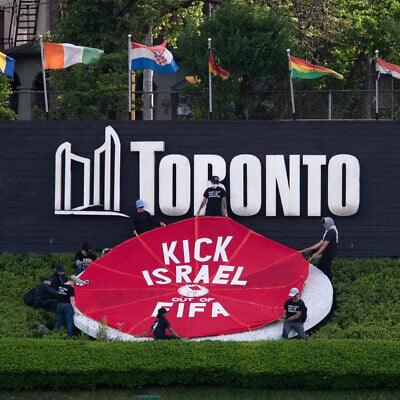 Activists place a banner covering the logo of the FIFA World Cup 2026 in Toronto, Canada, June 12, 2026. (Jorge UZON / AFP)