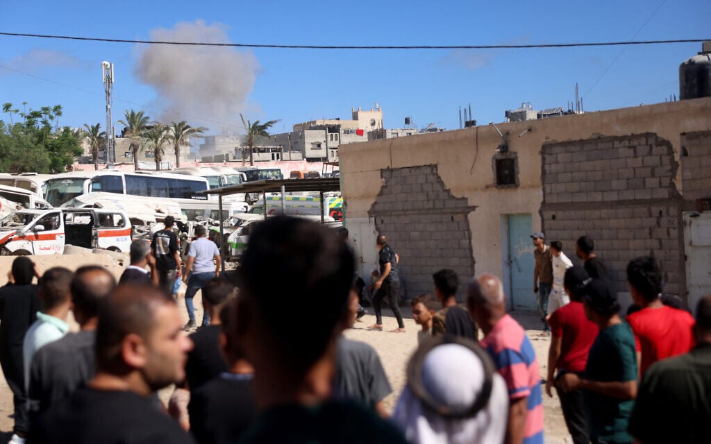 Palestinians look on as smoke rises following an Israeli military strike in Khan Younis, southern Gaza Strip on June 14, 2026 (Bashar Taleb / AFP) /