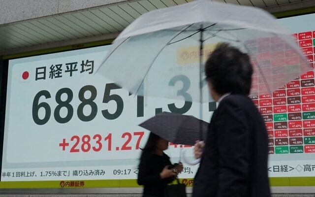 Pedestrians walk past an electronic quotation board displaying the Nikkei Stock Average on the Tokyo Stock Exchange in Tokyo on June 15, 2026. (Kazuhiro NOGI / AFP) Pedestrians walk past an electronic quotation board displaying the Nikkei Stock Average on the Tokyo Stock Exchange in Tokyo on June 15, 2026. (Kazuhiro NOGI / AFP)