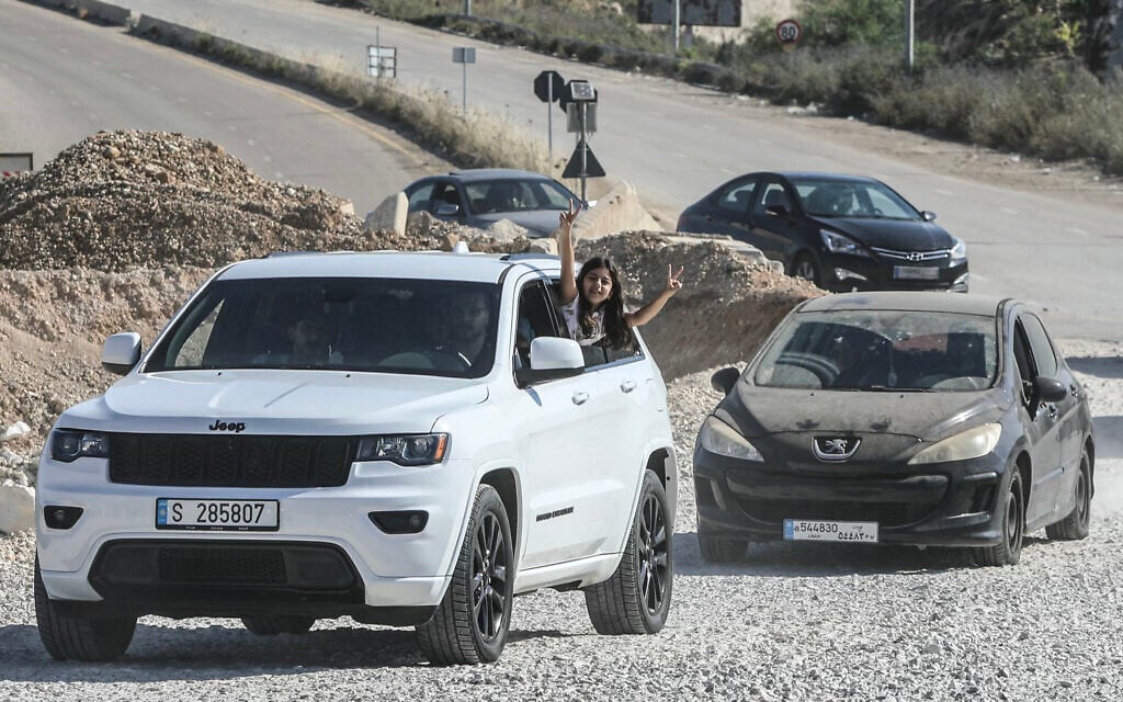 A girl flashes the V-sign from a vehicle as displaced residents cross the Bourj Rahal bridge on their way to their village in southern Lebanon on June 15, 2026 (Kawnat HAJU / AFP) /