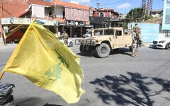 Lebanese soldiers man a checkpoint beside a Hezbollah flag at the entrance to Nabatieh on June 15, 2026, as displaced residents return to the southern city. (Mahmoud ZAYYAT / AFP)