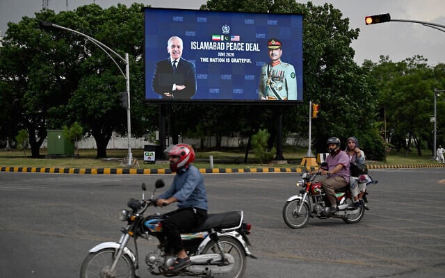 Commuters ride past an electronic board featuring Pakistan's Prime Minister Shehbaz Sharif (L) with Army Chief and Field Marshal Syed Asim Munir, displayed along a roadside in Islamabad on June 17, 2026, (Aamir QURESHI / AFP)