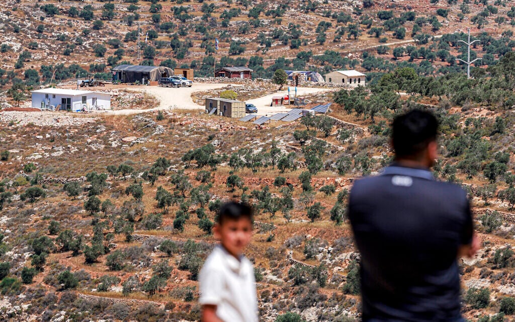 Palestinian men look at a newly-established Israeli settler outpost near the village of Jurish, south of Nablus in the West Bank, on June 20, 2026. (Jaafar ASHTIYEH / AFP)