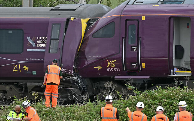 British Transport Police officers, Rail Accident Investigation Branch officers, and Network Rail work at the site of two East Midlands Railway (EMR) trains which crashed into each other on June 19, 2026, south of Bedford in central England on June 20, 2026. (JUSTIN TALLIS / AFP)