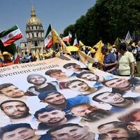 Protesters chant slogans as they hold a giant banner bearing the portraits of disappeared Iranian nationals, during an unauthorized demonstration by Franco-Iranian associations, near Place Vauban central Paris on June 20, 2026. (Arnaud Finistre/AFP)