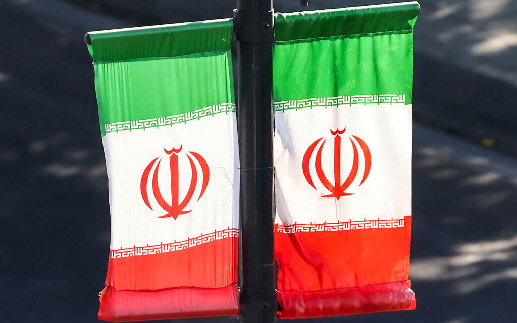 Iranian flags hang off a lamp post along a street in southern Tehran on June 20, 2026. (ATTA KENARE / AFP)