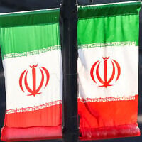 Iranian flags hang off a lamp post along a street in southern Tehran on June 20, 2026. (ATTA KENARE / AFP)