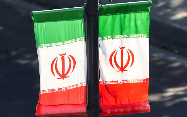Iranian flags hang off a lamp post along a street in southern Tehran on June 20, 2026. (ATTA KENARE / AFP)