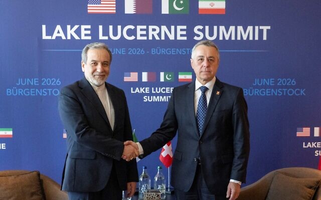 Iran's Minister of Foreign Affairs Seyyed Abbas Araghchi (L) and Swiss Federal Council, Ignazio Cassis shake hands as they take part in bilateral discussions at the Burgenstock resort in Obbuergen, near Lucerne on June 21, 2026. (URS FLUEELER / POOL / AFP)