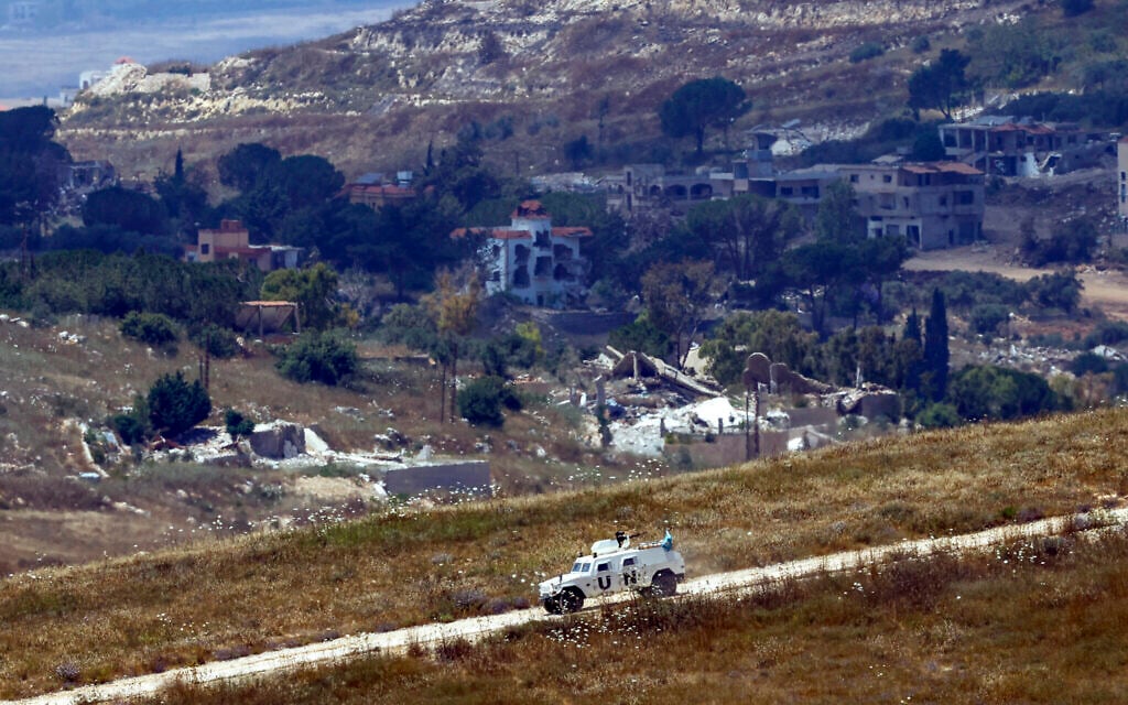 This picture taken from a position in northern Israel, near the border with Lebanon shows a United Nations Interim Force in Lebanon (UNIFIL) armored vehicle driving past destroyed buildings in southern Lebanon on June 22, 2026. (Jalaa MAREY / AFP) / This picture taken from a position in northern Israel, near the border with Lebanon shows a United Nations Interim Force in Lebanon (UNIFIL) armored vehicle driving past destroyed buildings in southern Lebanon on June 22, 2026. (Jalaa MAREY / AFP) /